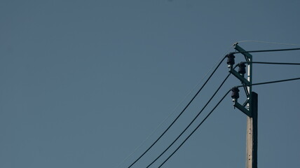 Power Pole with Electric Wires Against Clear Blue Sky During Bright Daylight Hours