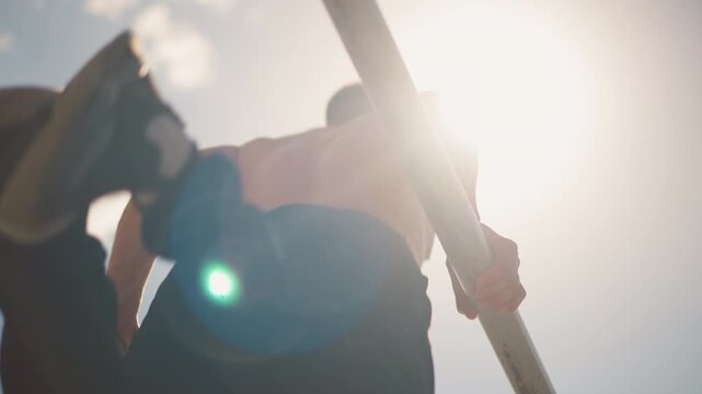man practicing dips on bars during sunset, caucasian man working out shirtless on parallel bars at sunset, athletic individual performing back dips shirtless against urban park sunset background