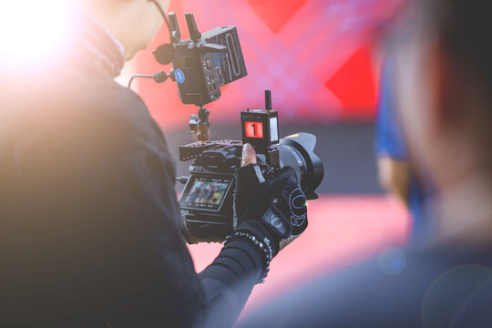 Video recording activities by on-stage photographers at sporting events.Professional videographer capturing the moment with high-end camera rig