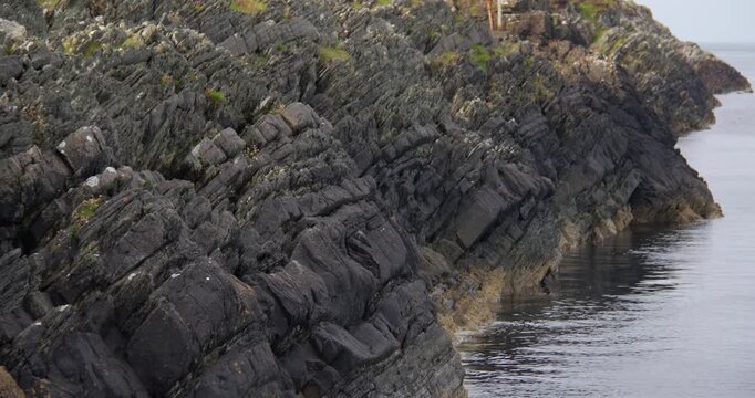 Extra wide shot of steeply inclined sedimentary rock like turbidite strata at Craignish Point, Sound of Jura.