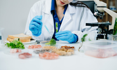  Food scientists woman using microscopes and pipettes in a modern laboratory environment.