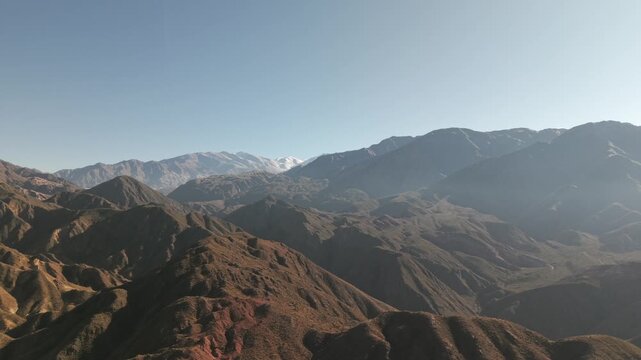 High wide aerial establishing monumental scale and geological complexity of Cuesta de Miranda, Chilecito within the Andean foothills of La Rioja, Argentina, with distant peaks showing snow or glaciers