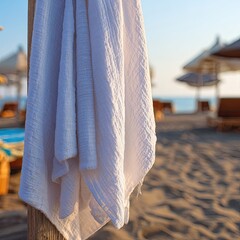 White Beach Towel Hanging On Wooden Post At Beach