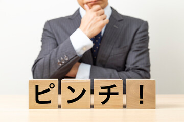 「ピンチ！」と書かれたブロックとビジネスマン