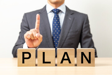 「PLAN」と書かれたブロックとビジネスマン