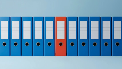 A row of blue binders, with one red binder in the middle, stands against a light blue background. Each binder has a white label area