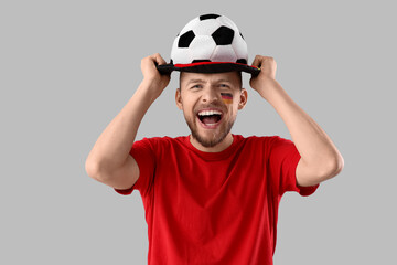 Male German soccer fan with hat on light background