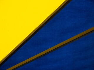Close up of a big market umbrella with blue and yellow tarpaulin canvas and steel frame.