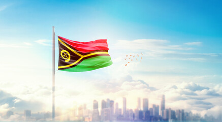 Vanuatu flag wavering in beautiful clouds with building skyline. The flag with drone shot in...