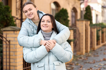 Fototapeta premium Beautiful women hugging on street
