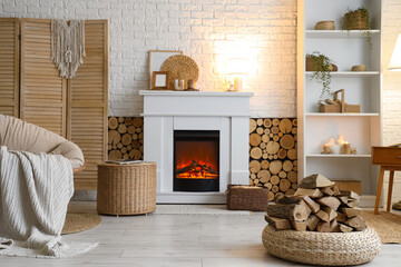 Fototapeta premium Interior of living room with armchair, shelving unit, folding screen, coffee table and firewood near fireplace