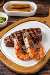 Tenderloin (bonfile) steak plated with large grilled prawns