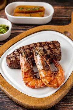 Tenderloin (bonfile) steak plated with large grilled prawns