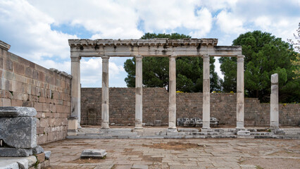 Fototapeta premium Ancient Asclepieion of Pergamon ruins, Bergama, Turkey. Colonnade with fluted columns and stone walls under a cloudy sky.