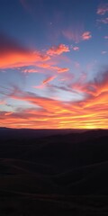 Vast painted sky ablaze with fiery sunset hues over rolling hills,  landscape,  sky