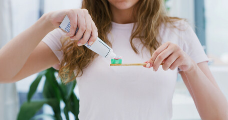 Woman, hands and toothbrush in bathroom with toothpaste for morning routine, dental hygiene or wellness. Female person, brushing teeth and getting ready in home for oral care, clean and fresh breath.