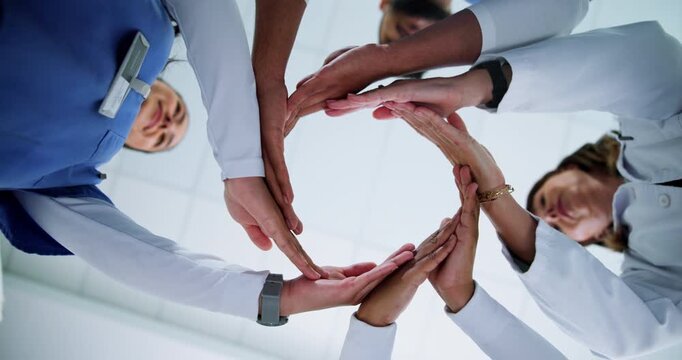 Below, nurses and doctor with hands circle for huddle, teamwork or motivation in hospital. People, employees or healthcare professionals with link for medical solidarity, collaboration or support