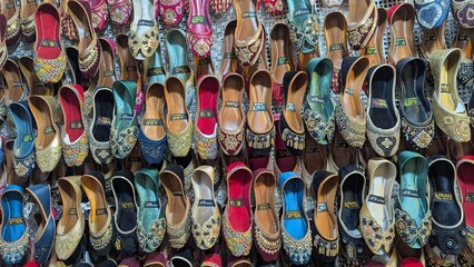 Row of colorful hand made traditional Rajasthan style shoes up for sale at street side in Area Hazro Attock. &lrm;November &lrm;28, &lrm;2025 