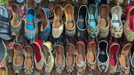 Row of colorful hand made traditional Rajasthan style shoes up for sale at street side in Area Hazro Attock. &lrm;November &lrm;28, &lrm;2025 