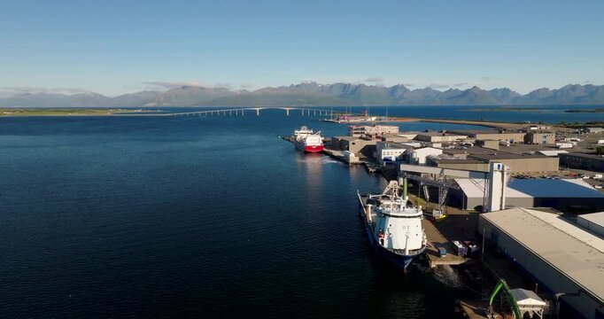 Fishing Boats Docked In The Harbor With Skagenkrysset In Stokmarknes, Norway. - aerial shot