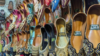 Row of colorful hand made traditional Rajasthan style shoes up for sale at street side in Area Hazro Attock. &lrm;November &lrm;28, &lrm;2025 