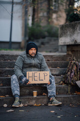 Homeless man begging for help on street stairs