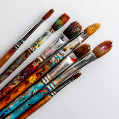 Collection of colorful used paintbrushes on a white background