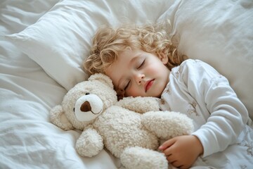 Young child with curly blonde hair sleeps peacefully with soft stuffed bear. Toddler rests on white pillow, blanket, embraced by soft light. Adorable scene captures childhood innocence, bedtime