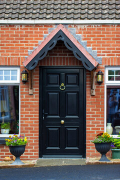 Black Front Door With Ornate Trim On Brick House, in Ireland