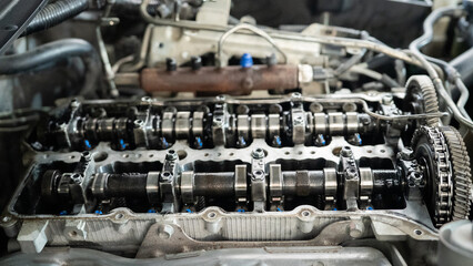 The engine of a car is shown with the cylinders and pistons visible. The engine is dirty and has a lot of oil on it