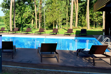 Summer relaxation. Sun loungers line the perimeter of the outdoor pool.