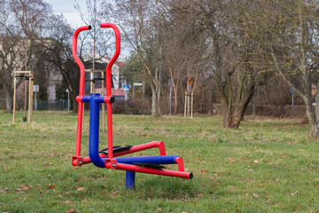 Fototapeta premium Urządzenie do ćwiczeń na siłowni plenerowej w parku – trening na świeżym powietrzu i rekreacja na osiedlu.