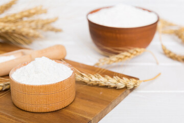 Flat lay of Wheat flour in wooden bowl with wheat spikelets on colored background. world wheat crisis