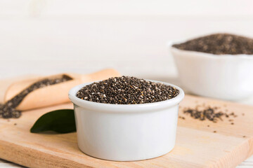 Chia seeds in bowl and spoon on colored background. Healthy Salvia hispanica in small bowl. Healthy superfood