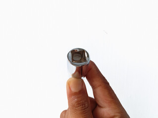 Close-up photo of a human hand holding a chrome socket tool, isolated on white background, showing mechanical detail and grip clarity.