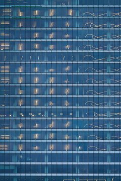 Modern business glass facade building with illuminated office windows