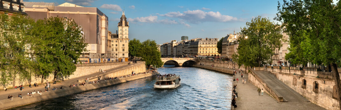 Paris France people in boats move along Seine River panorama