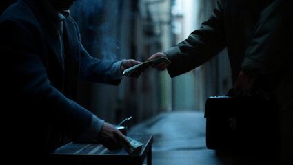 Bribe and illegal deal concept closeup of two men hands exchanging money in dark alley during secret meeting