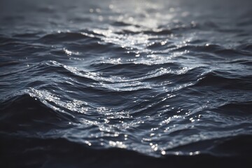 Dark Blue Ocean Water Surface with Glimmering Sun Reflecting Light and Rolling Wave Patterns Abstract Background Moody Atmospheric Lighting Tranquil Nature Scenery