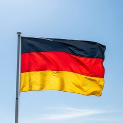 A vibrant national banner in the wind against a clear, azure sky. The flag's horizontal tri-color design is fully unfurled