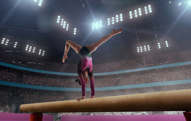 A gymnast performs a difficult trick on a balance beam.
