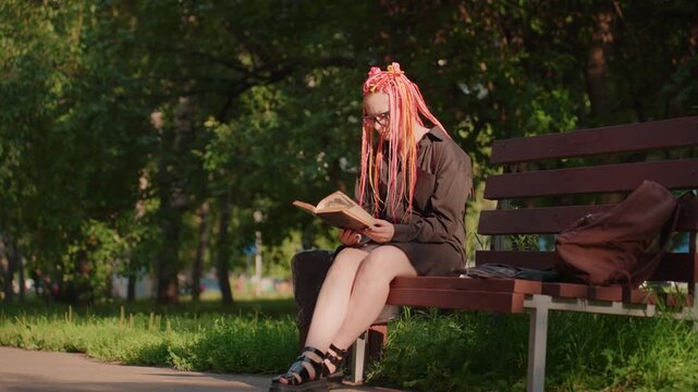 woman reads peacefully, serene woman immersed in book outdoors, tranquil lady enjoying quiet reading under trees, woman peacefully escapes into literature beneath lush green foliage