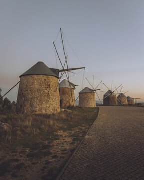 View of historic windmills stand proudly against the skyline, their rustic stone textures contrasting with the smooth path, Moinhos de Gavinhos, Coimbra, Portugal.