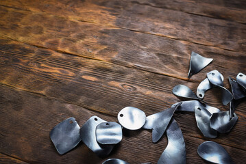 Metal armor plates scattered on wooden table toop view background.