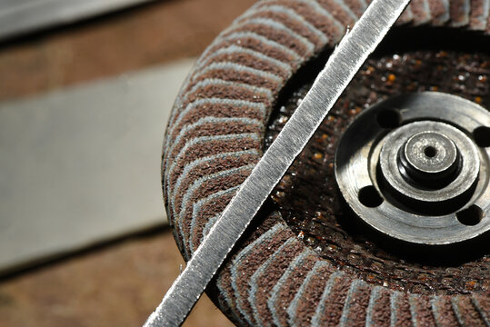 Close up view of abrasive flap disc metal hub and grinding wheel surface during metalworking process on industrial workshop top view background.