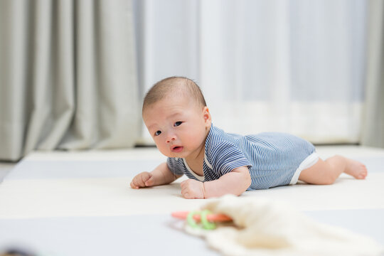 Little newborn baby practicing tummy time and lifting head