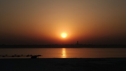 Peaceful Sunset Reflection Over Calm Water with Silhouetted Trees Creating Serene Nature Landscape