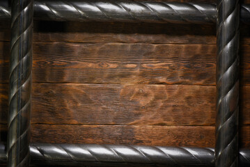 Two twisted steel pipes framing empty space on wooden workbench table top view background with copy space.