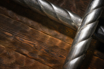 Two twisted steel pipes framing empty space on wooden workbench table top view background with copy space.