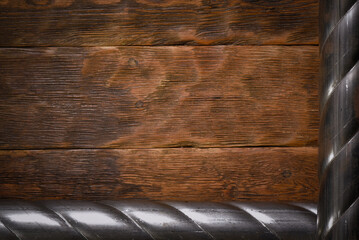 Two twisted steel pipes framing empty space on wooden workbench table top view background with copy space.